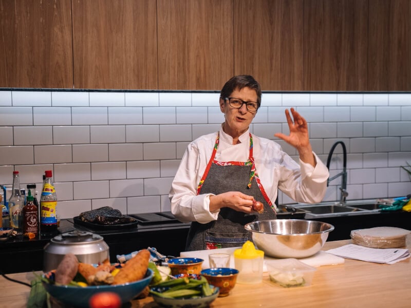 A teacher wearing an apron at a cooking class