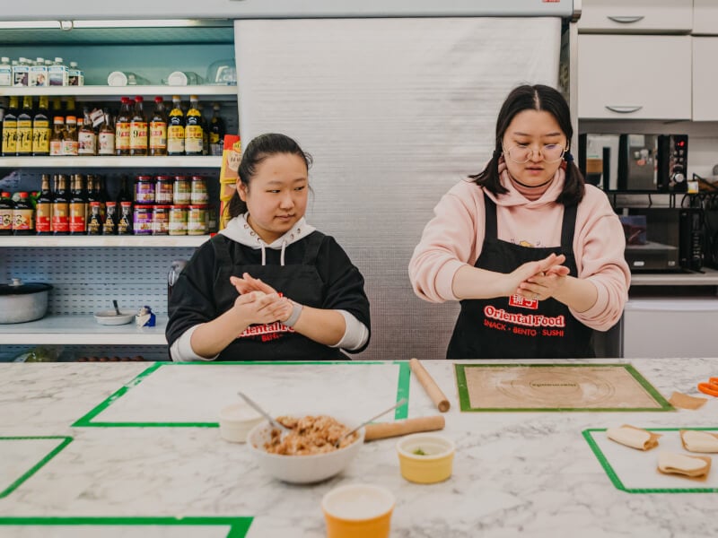 Two women making dumplings at a cooking class