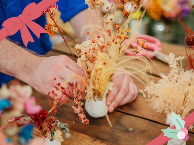 A dried flower arrangement in a handmade ceramic vase