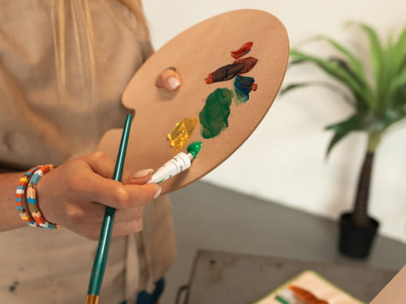 A woman holding a pallette at a painting class