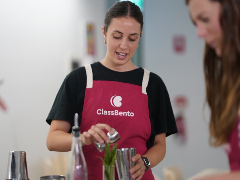 Woman wearing apron making a DIY cocktail
