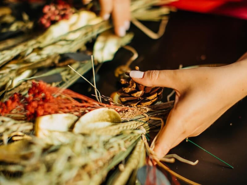 Close up on hands holding a bundle of dried flowers and foliage