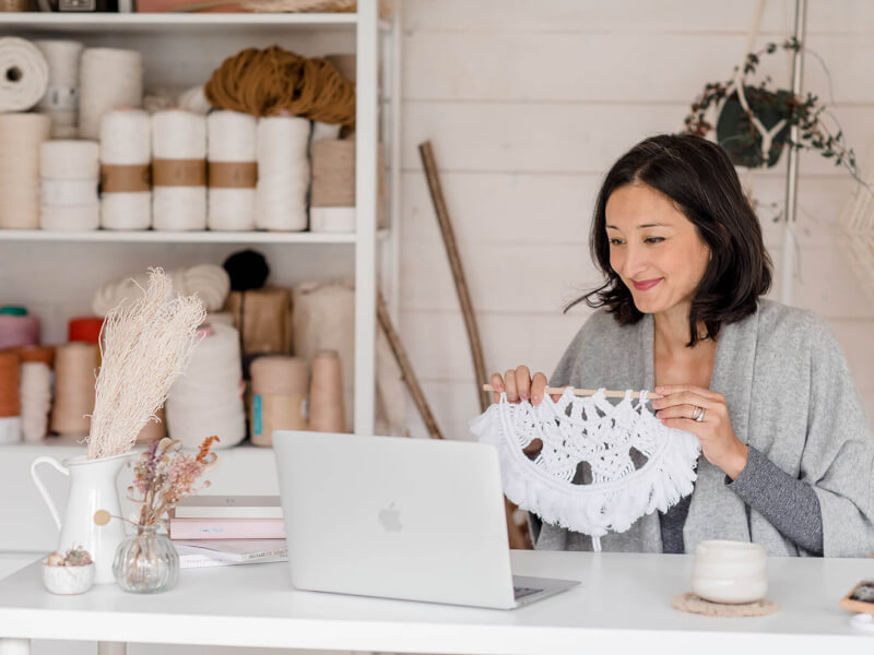 Macrame teacher Isabella Strambio showing a finished piece of macrame at an online workshop