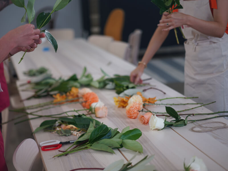 A white table filled with flower stems at a floristry class.