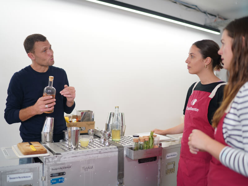 Two women learning how to make cocktails.