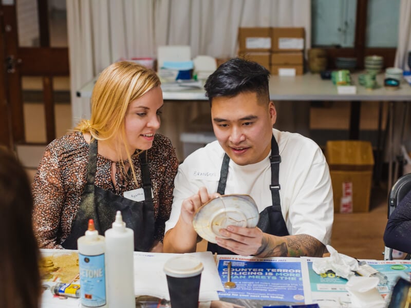 A couple sit next to each other in a craft workshop