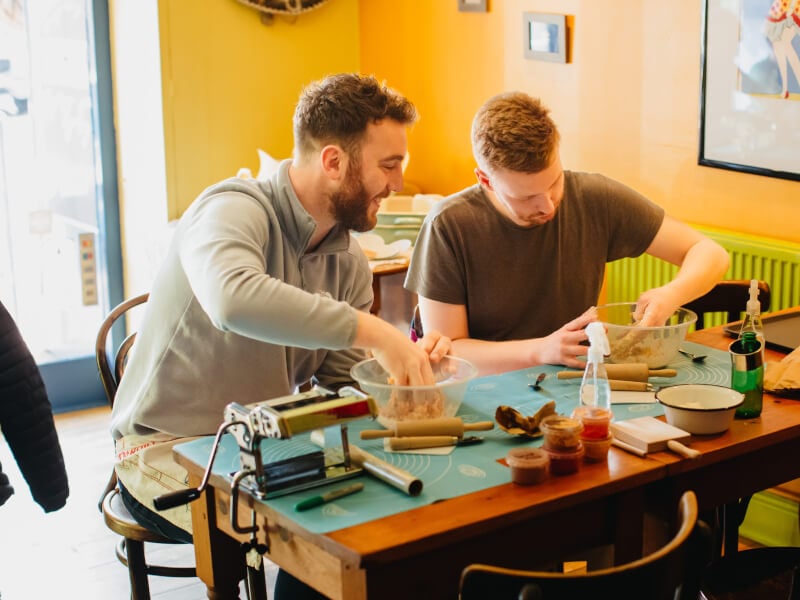 Two men learn how to make pasta dough at a cooking date night.