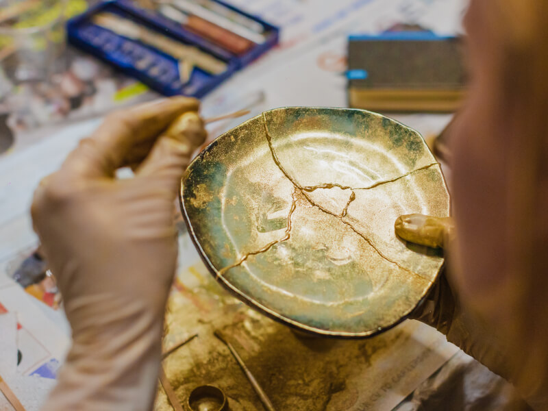 Hands fixing pottery in a Kintsugi pottery class