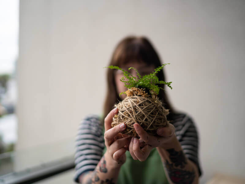 Woman holding a kokedama she made