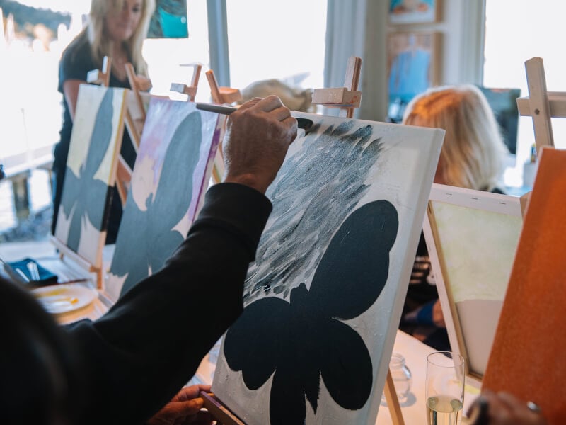 A line of canvases of paintings at an art class.