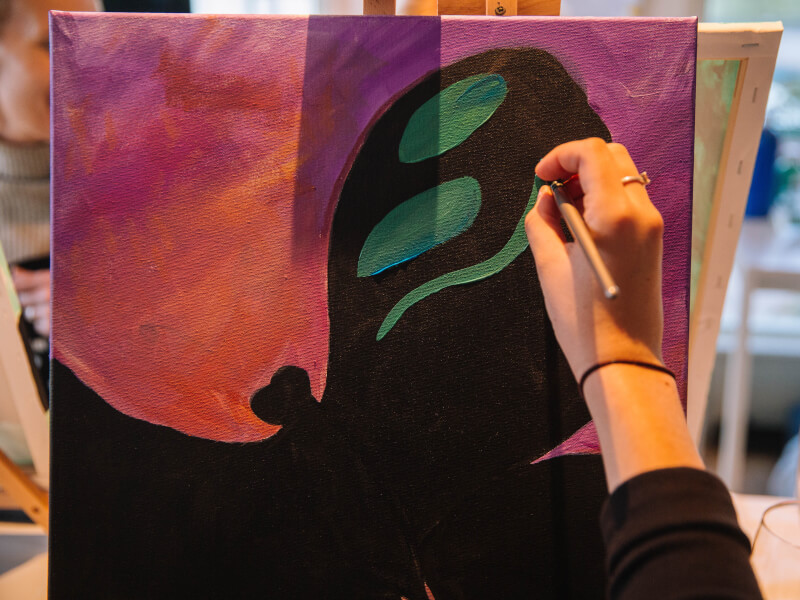 A person paints a butterfly in a painting course.
