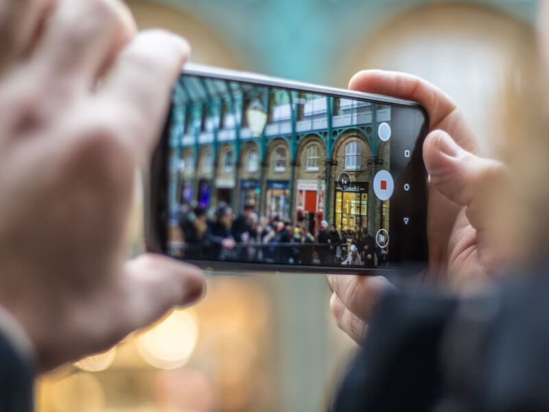 A person is using their smartphone to take pictures in a London photography class.