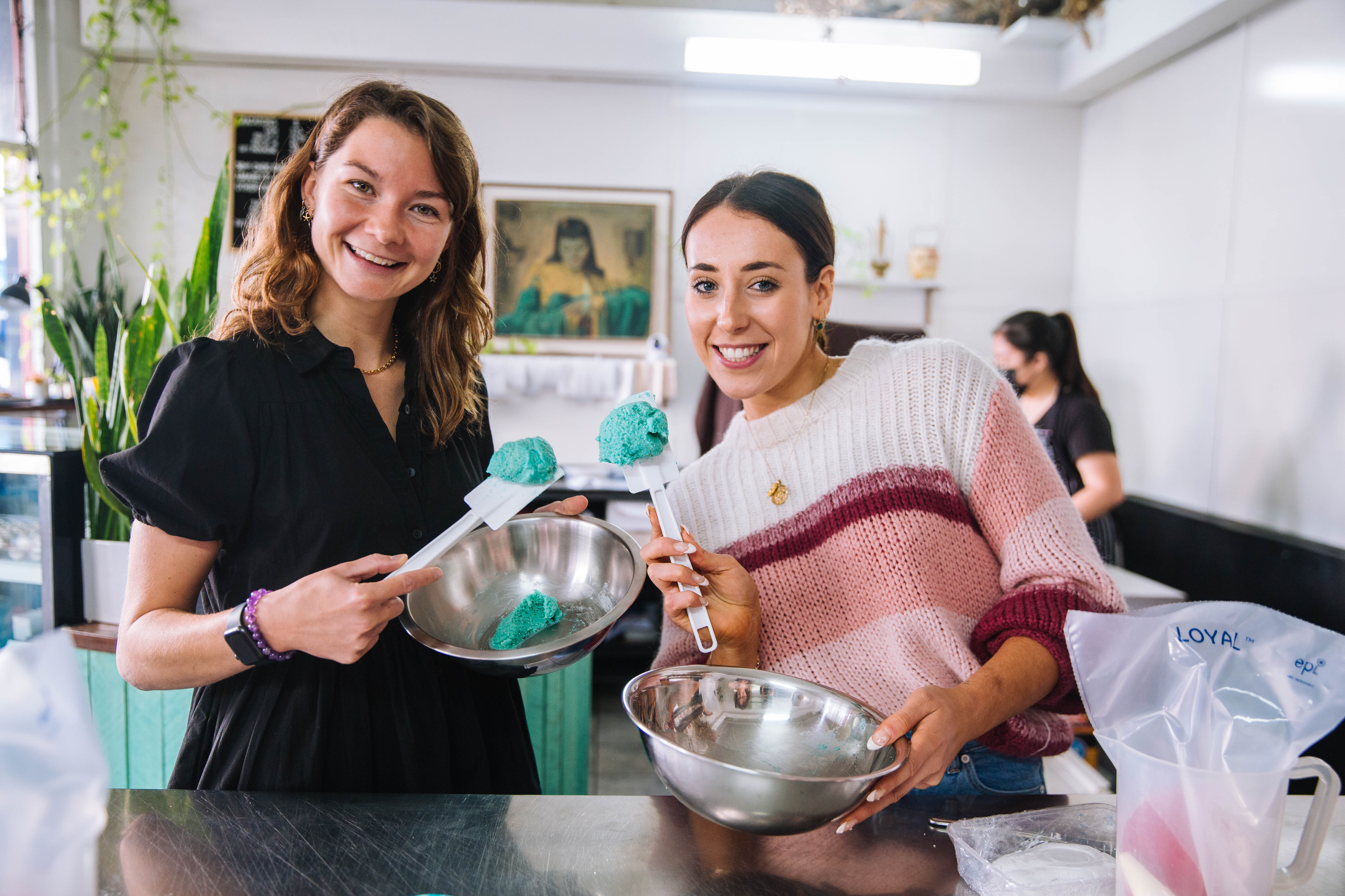Two people posing for the camera as they make macarons together