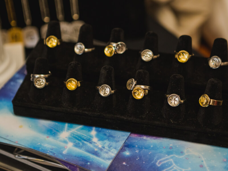 A selection of handmade gold and silver rings on black ring sizing tools