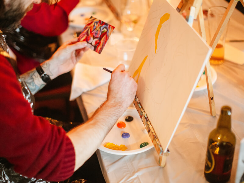 A person is sketching a picture of a lion ready to paint at a paint and sip art class