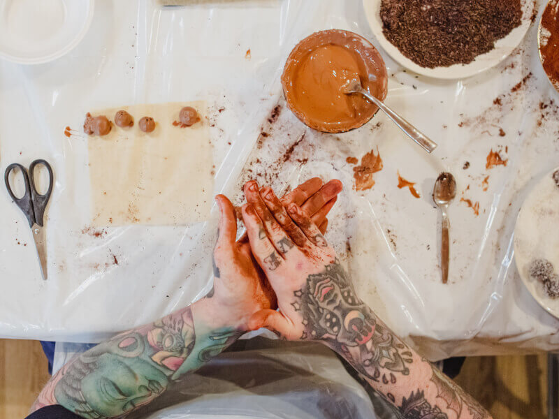 Top down view of someone rolling handmade truffles.