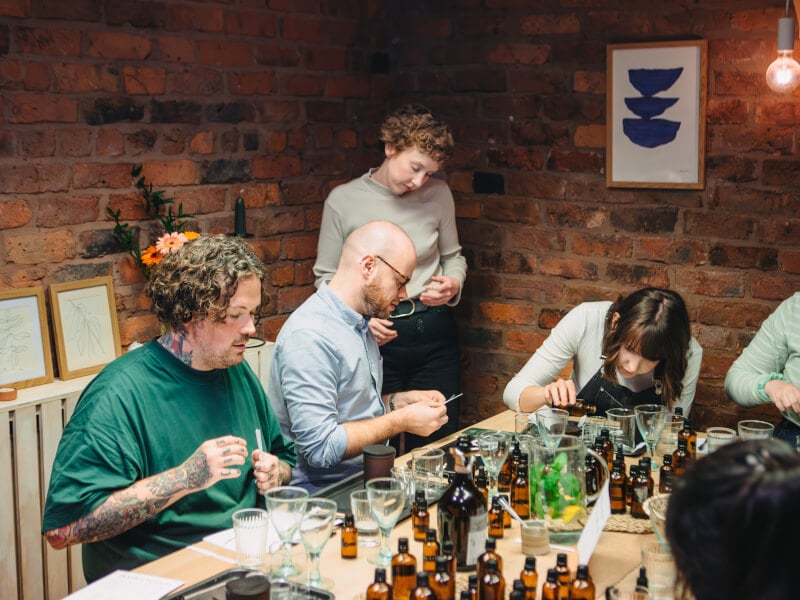 People measure and smell oils in a beauty Manchester class.