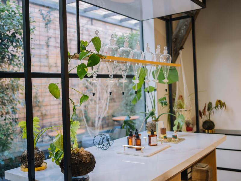 An assortment of perfumery tools and ingredients at a display in a workshop window