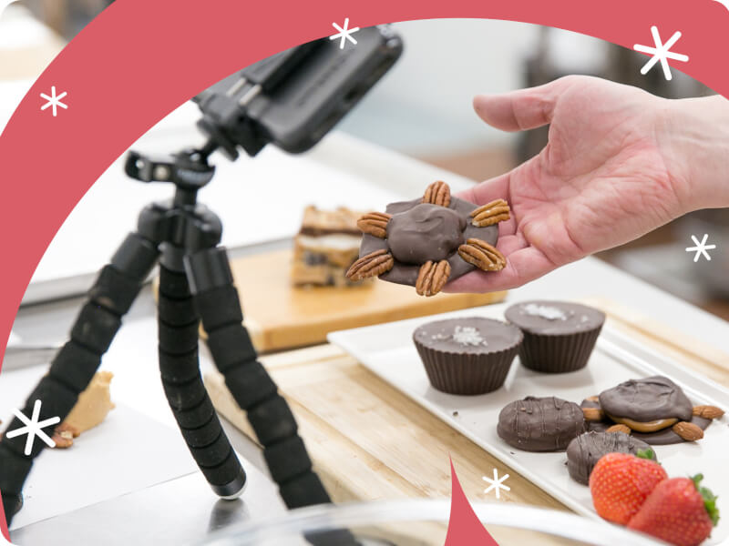 A close up of a person holding handmade chocolate up to a camera