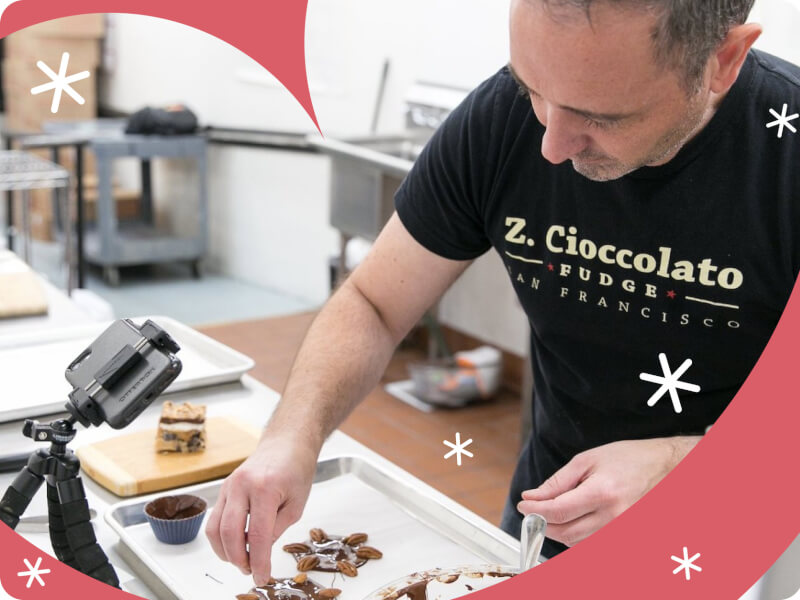 A person is adding nuts to handmade chocolates