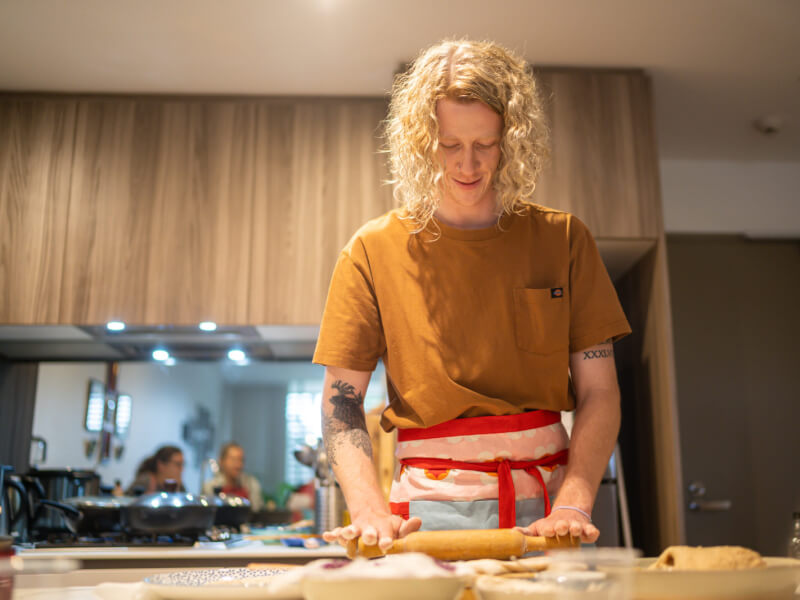 A man rolling dough at an Indian cooking class.