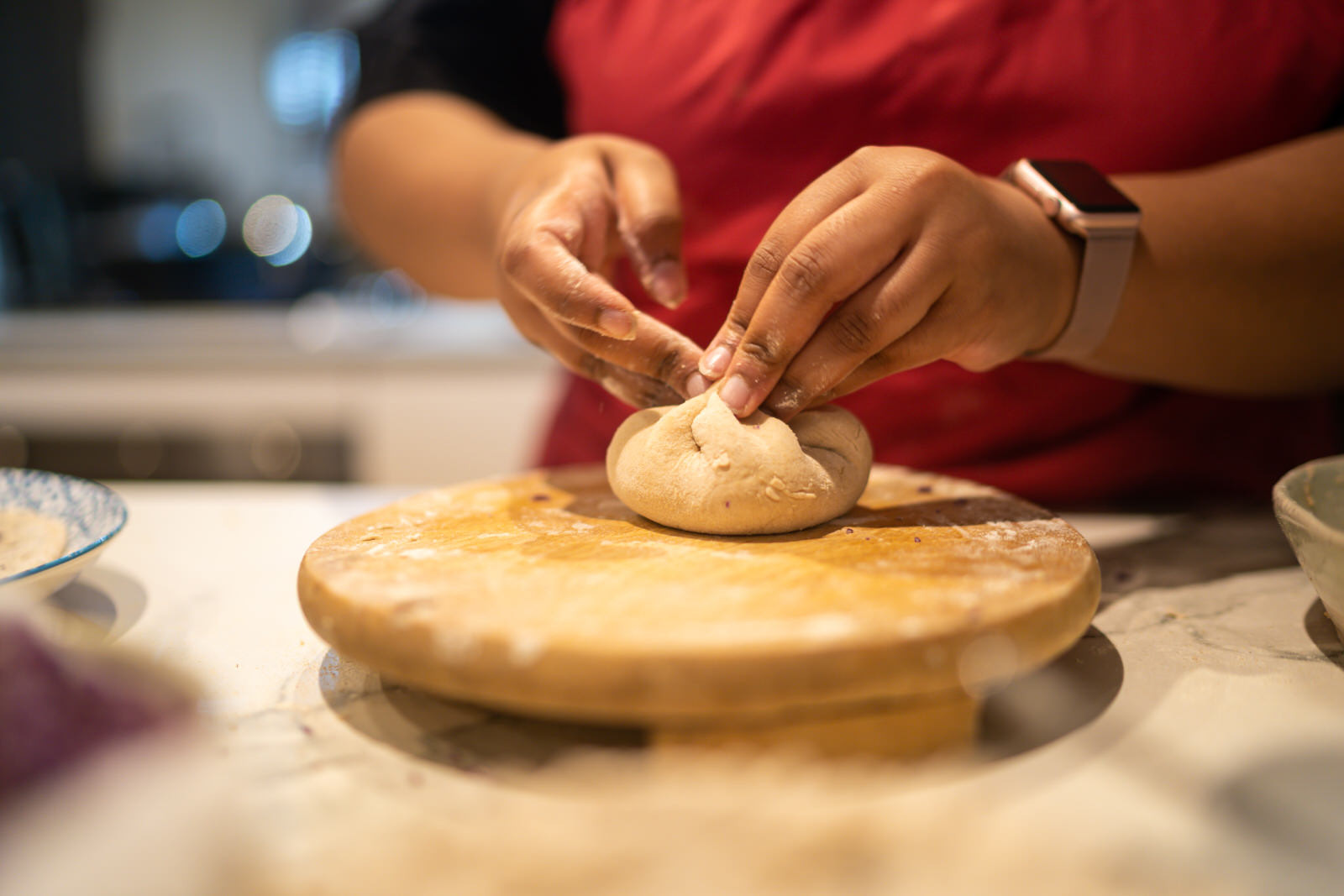 Close up of a woman kneading a ball of dough