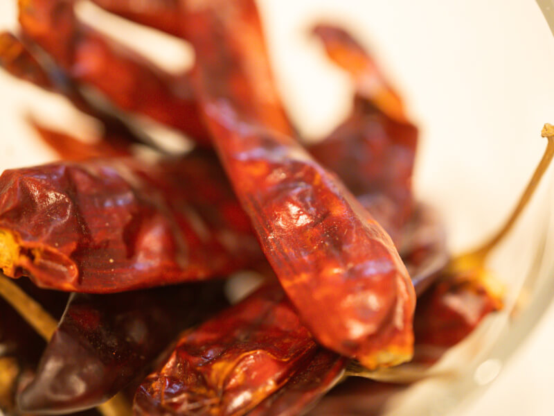 Macro close-up of a bowl of dried whole chillies