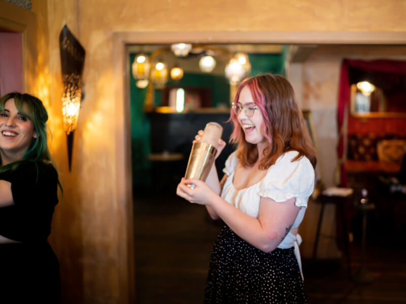Two women making cocktails at a hen party in London.