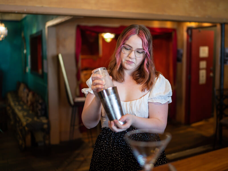 A woman holding a shaker at a London cocktail class.