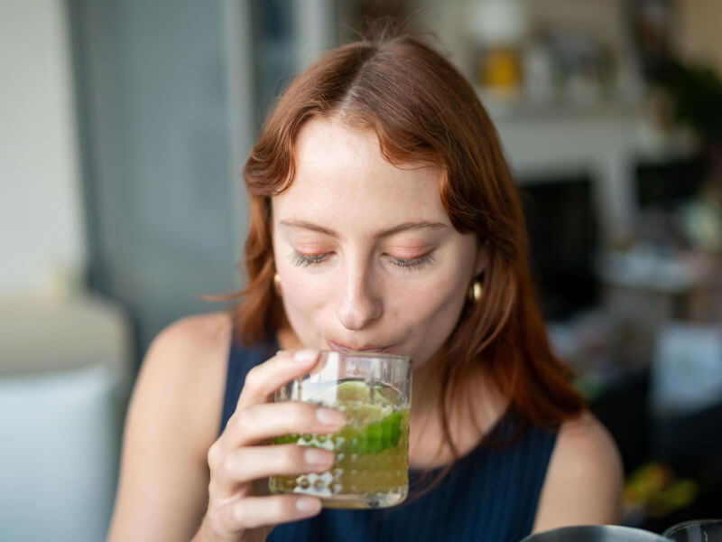 Person tasting a gin-based cocktail