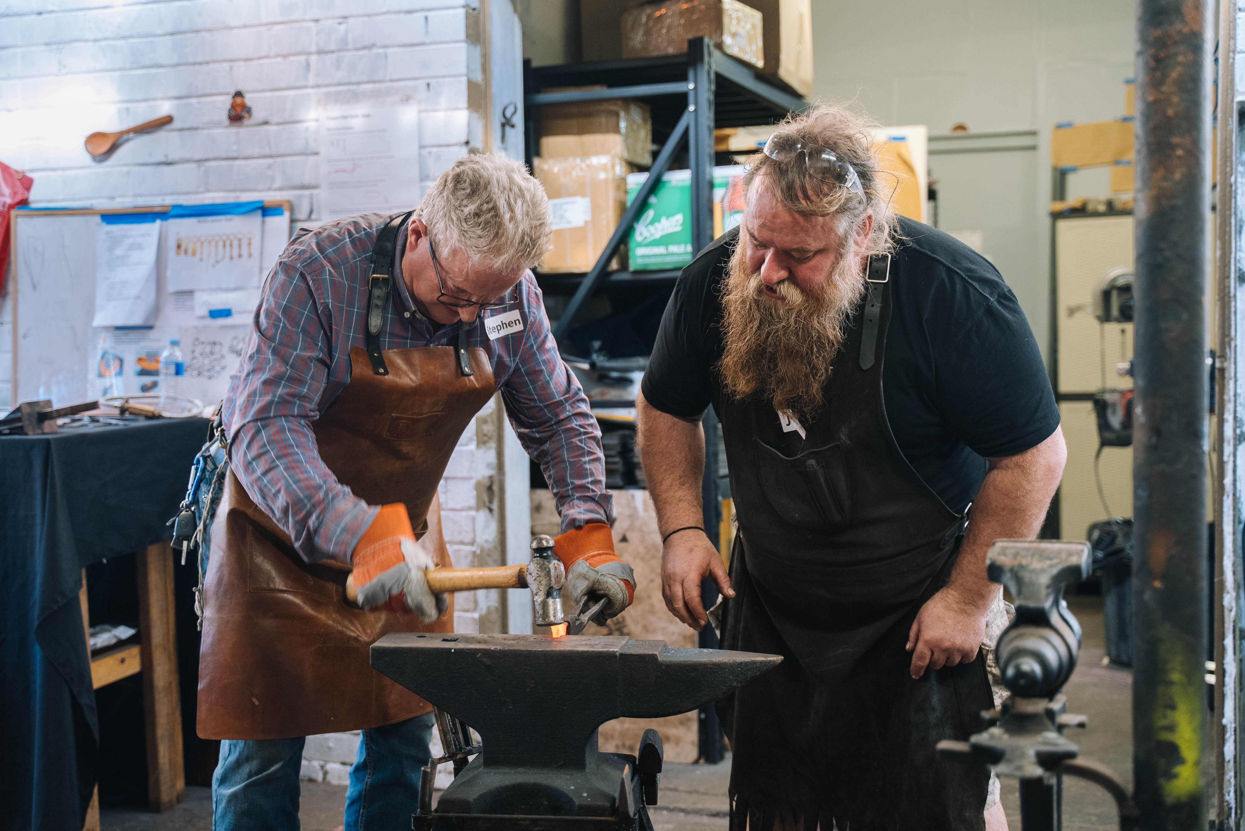 A student and teacher at a blacksmithing class