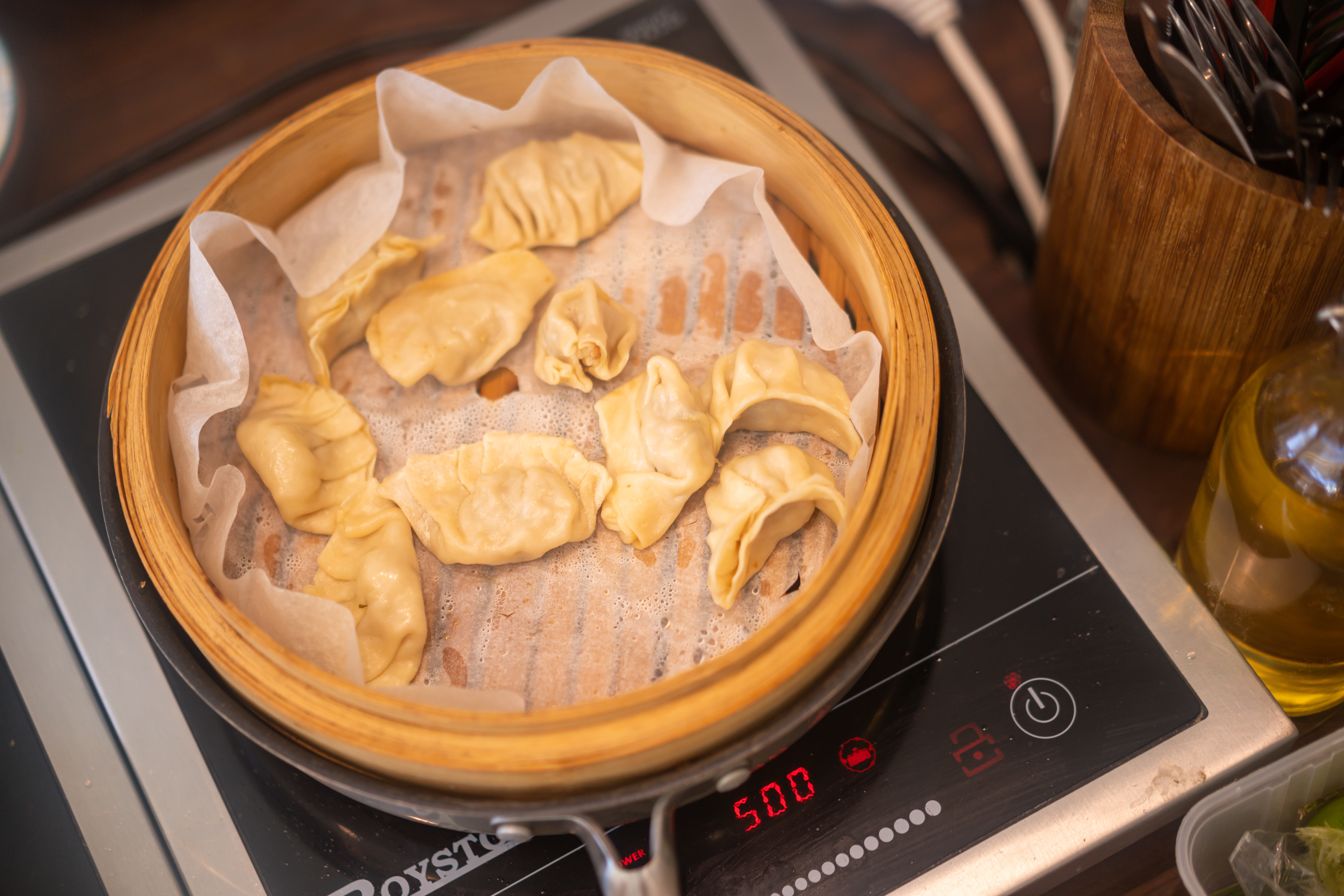 Gyoza dumplings steaming in a bamboo steamer