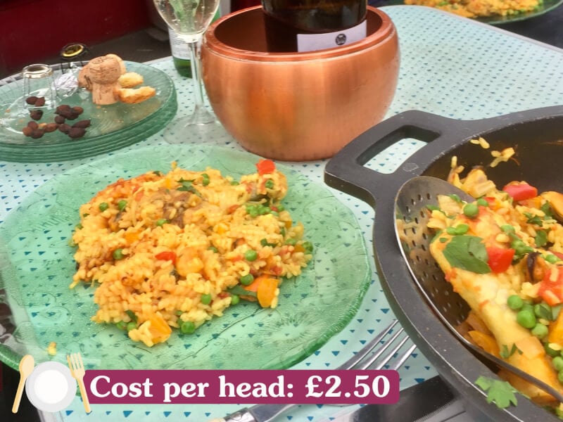A table with a dish of paella. 