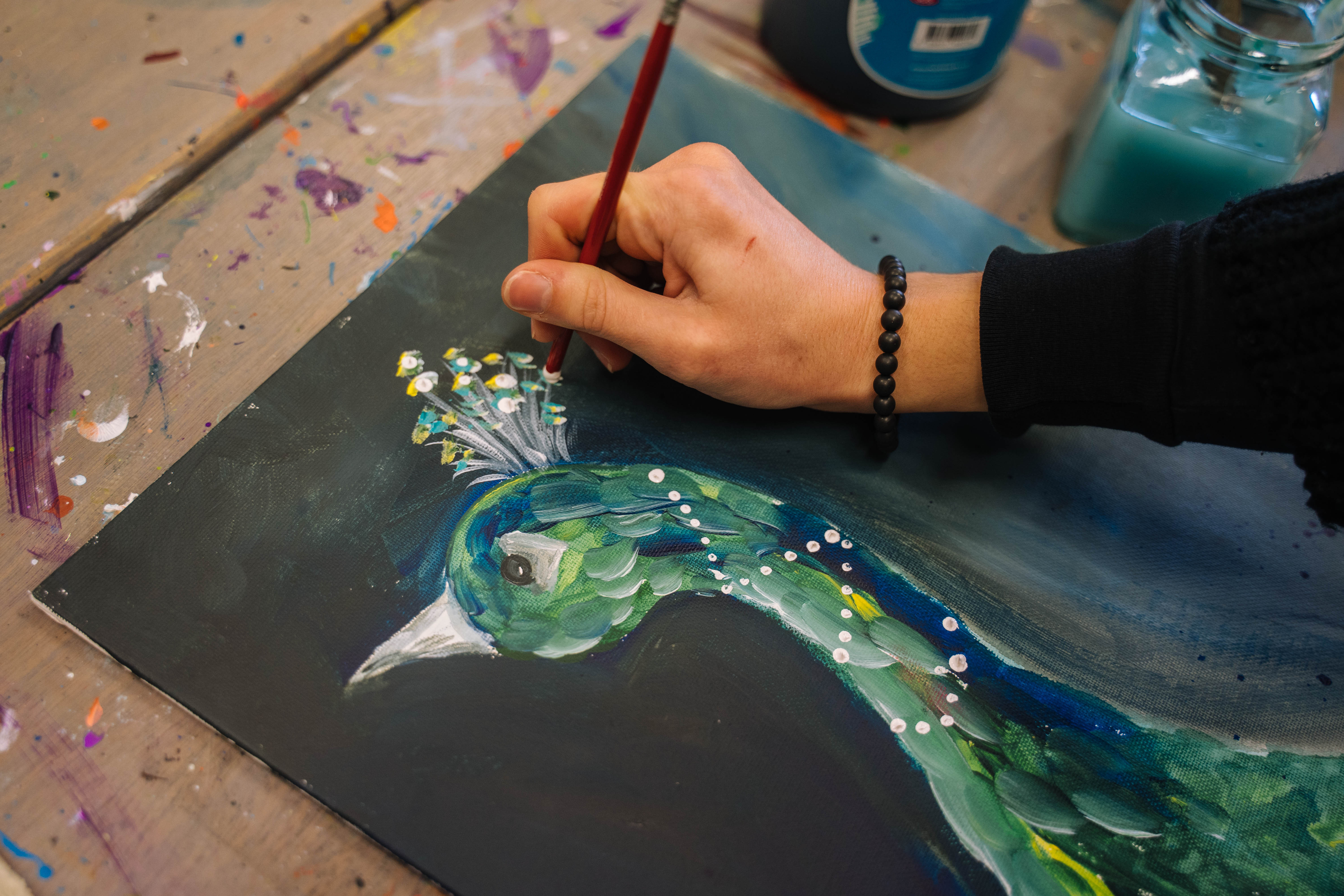 Close up of person painting a peacock