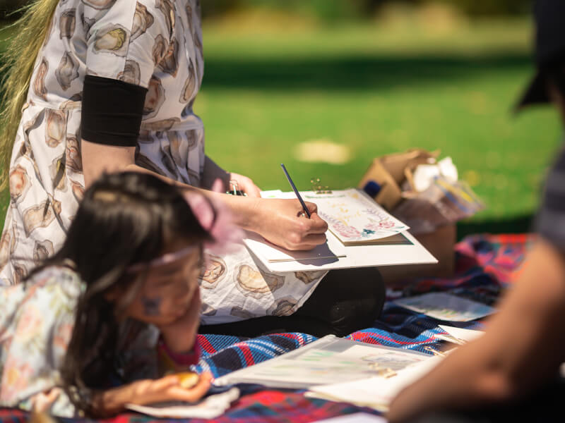 Person in a park sketching/painting in an art class