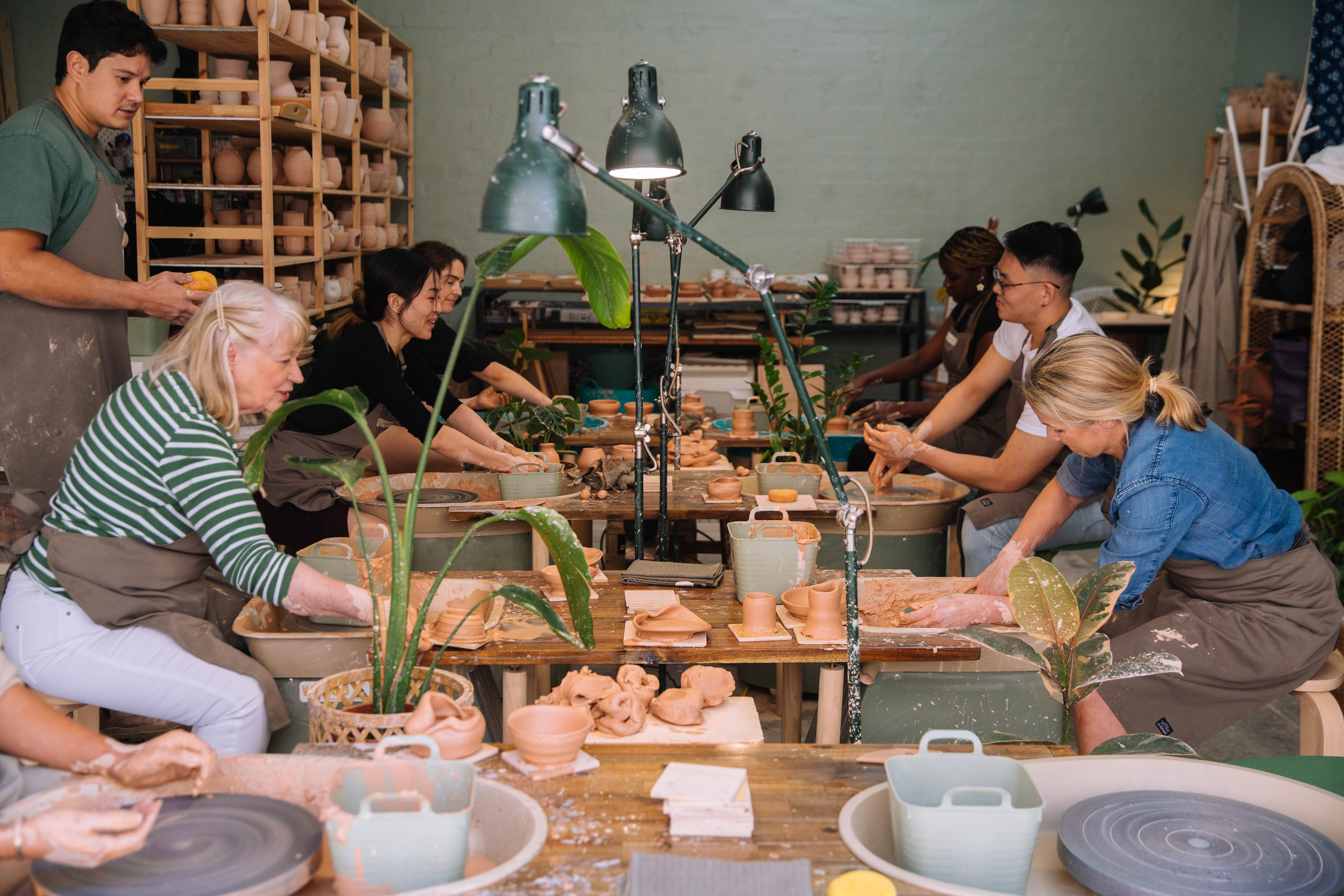 A group of people working together at a pottery class