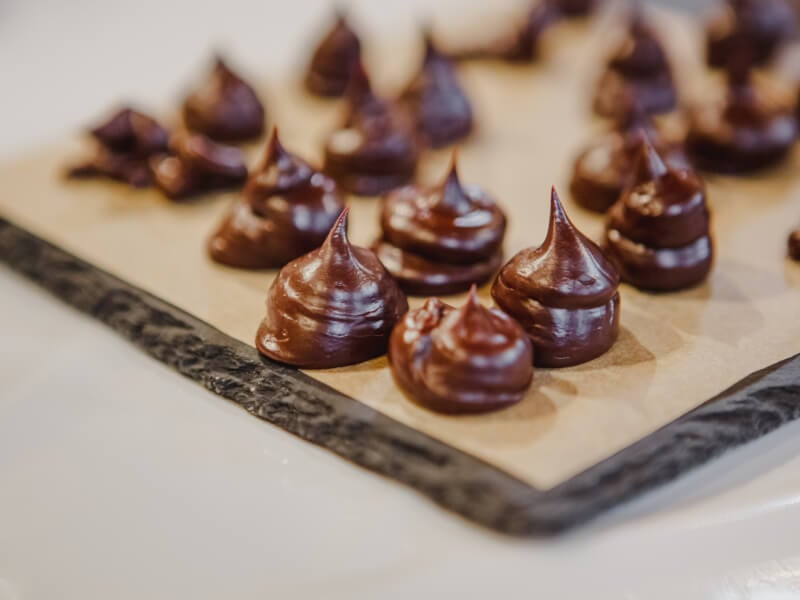 A tray of fresh handmade chocolate sweets sits on a table