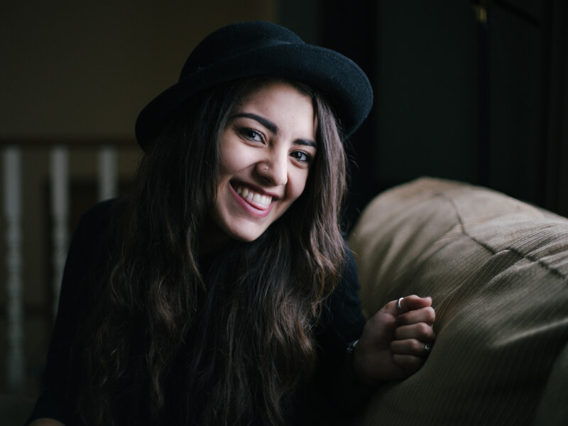 A person sitting on a couch, smiling at the camera