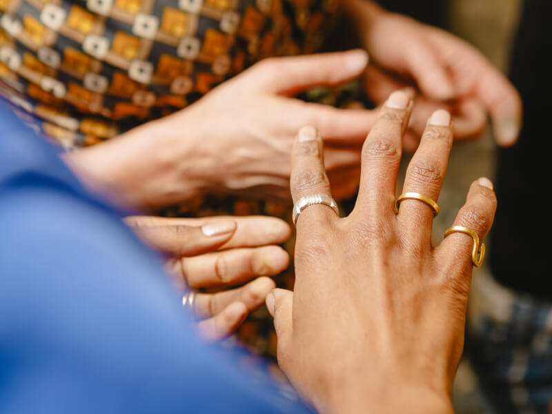 Two hands wearing a range of rings