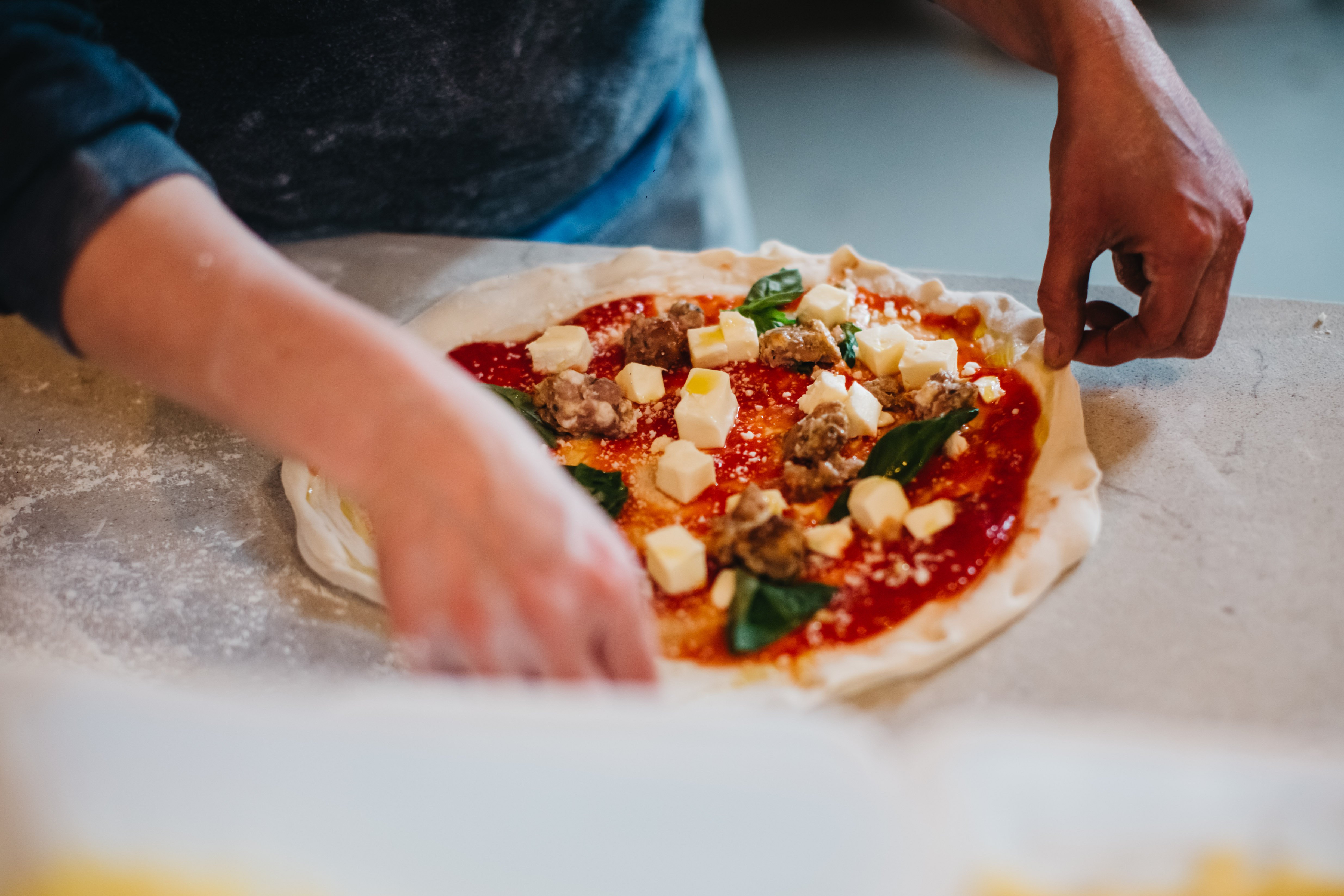 Hands preparing a traditional Neapolitan pizza