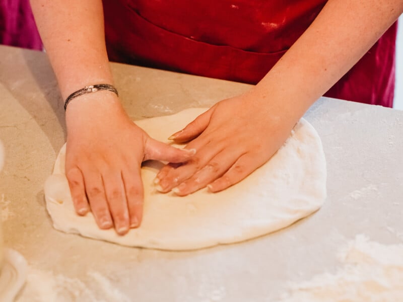 Hands kneading dough at a sourdough bread making class.