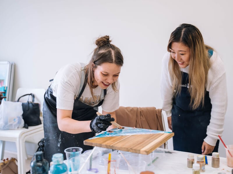 Two people at a paint pouring class