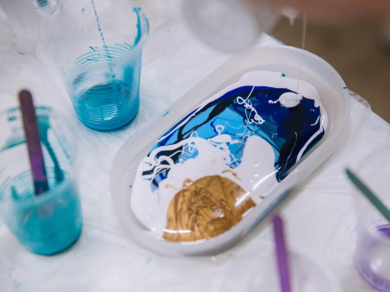 A melange of coloured paints on an oblong shaped plate