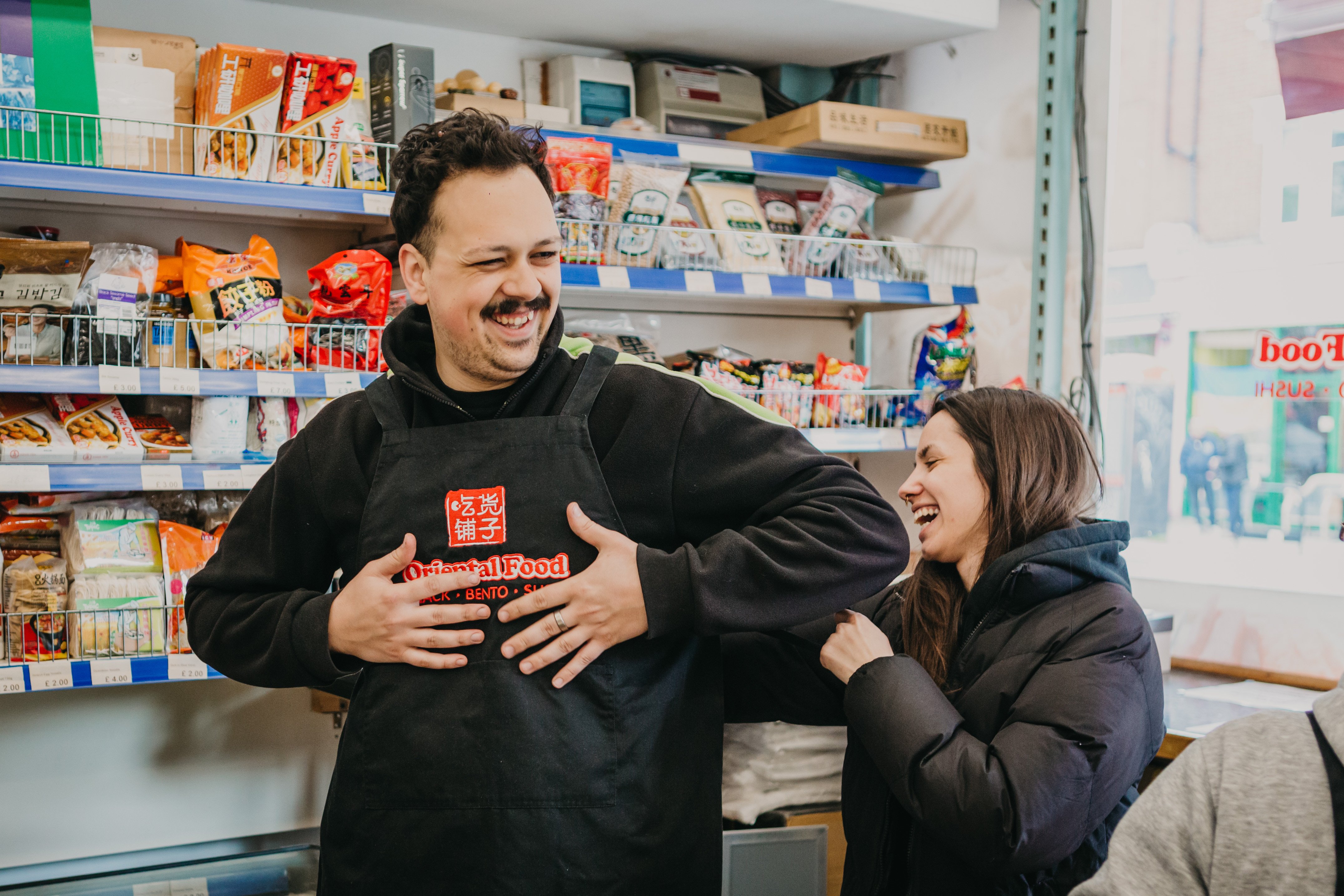 A couple smiling and laughing at a cooking class