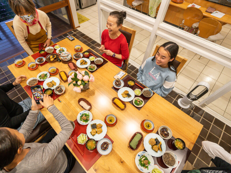 People sitting around a table enjoying a variety of Asian dishes