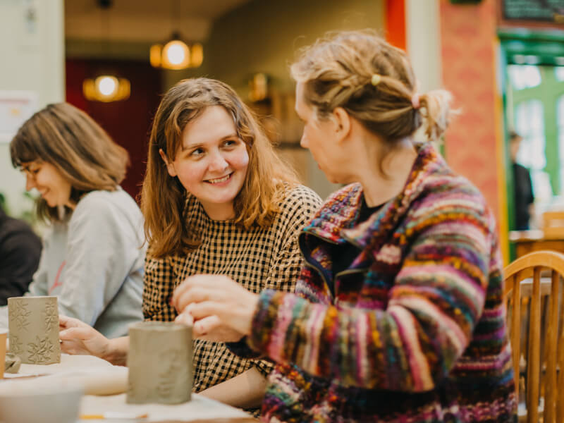 A photo of two women in a pottery studio.