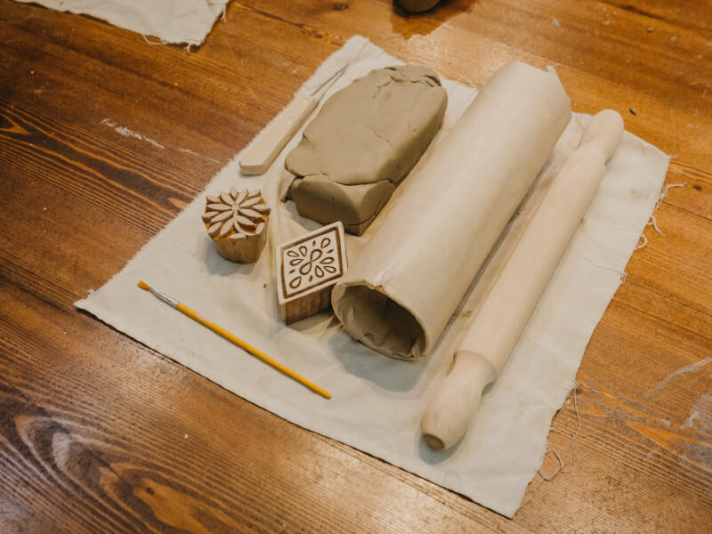 A lump of clay next to some pottery tools.