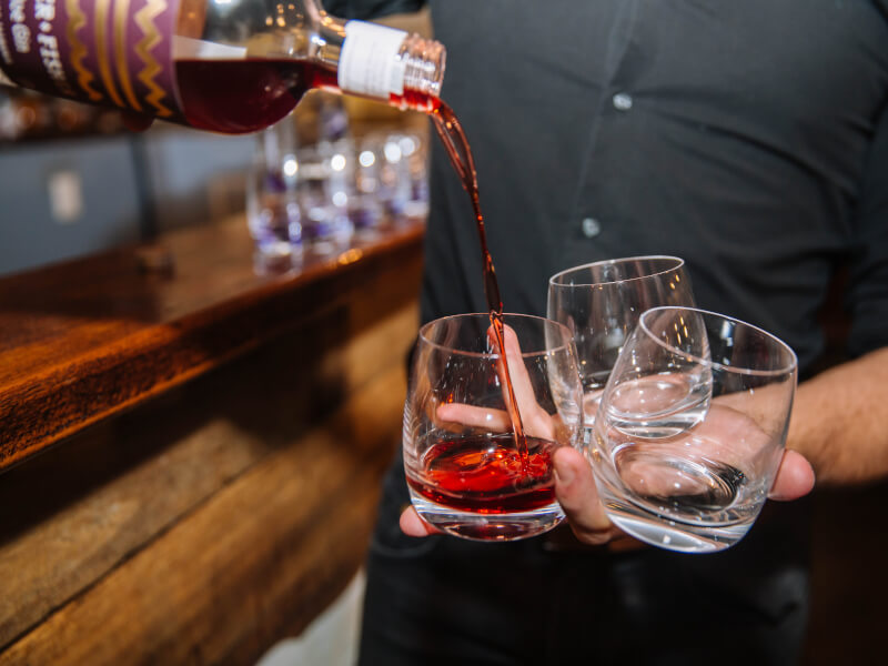 Someone pouring into 3 glasses