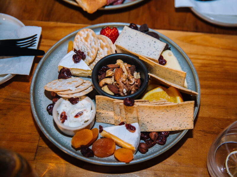 A plate of cheese, crackers and nuts