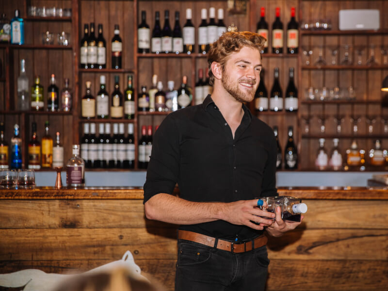 Barman talking in front of a bar at a wine tasting in London